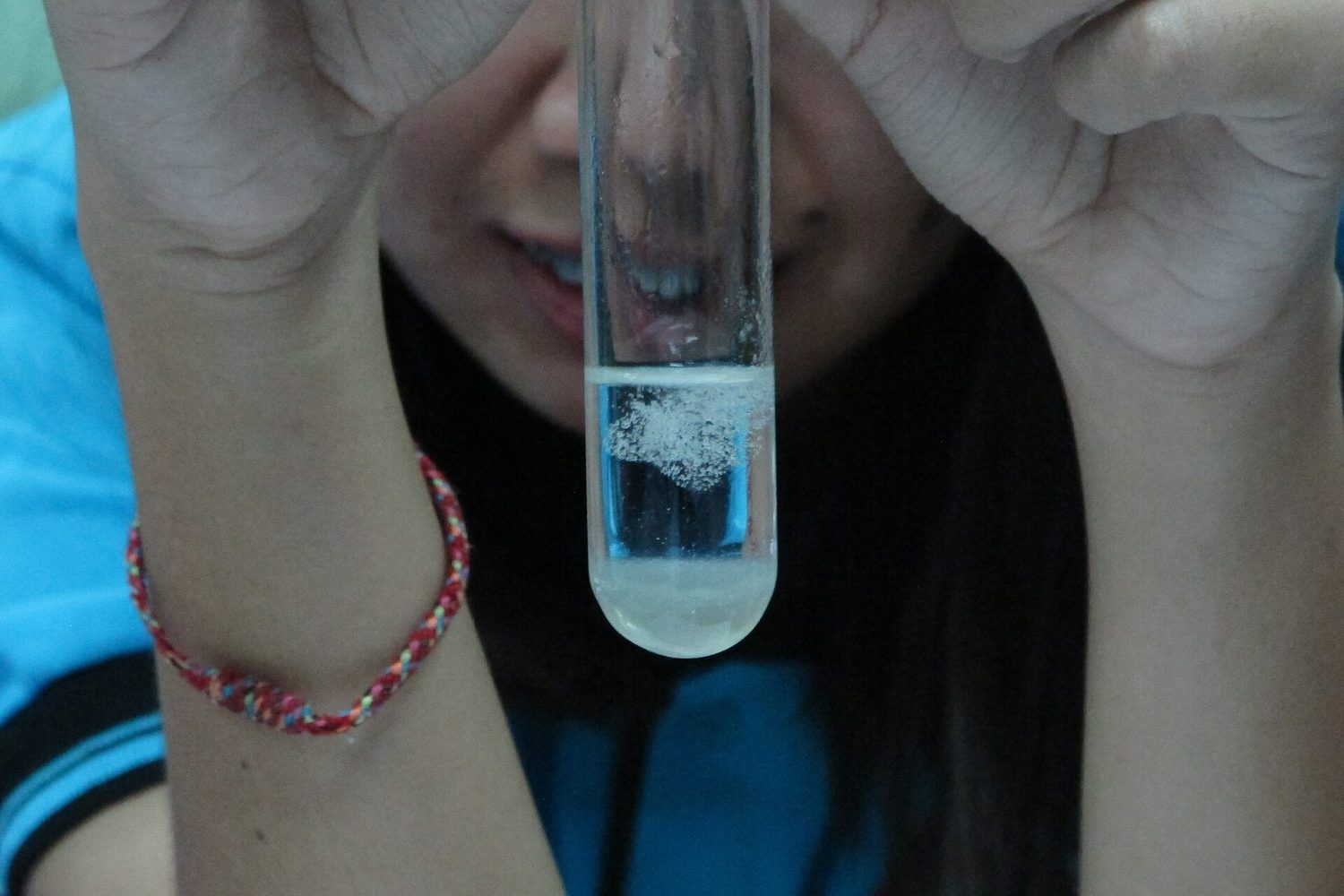 Pale, stringy strands of DNA in a tube