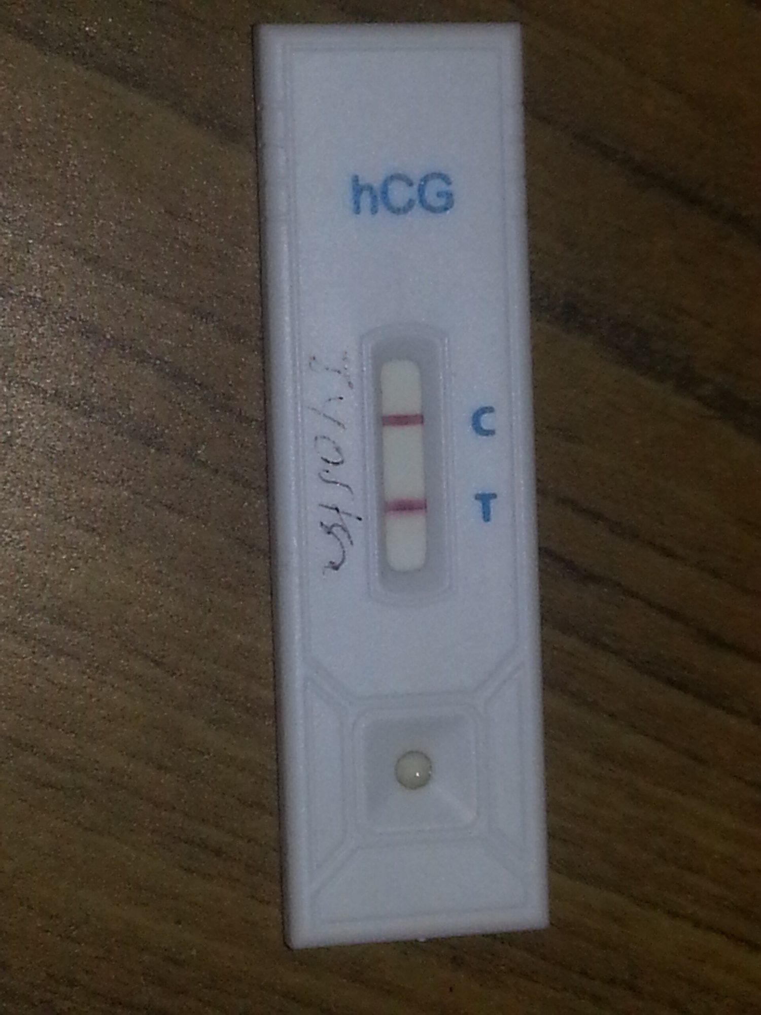 A pregnancy test cassette labelled hCG showing two red lines beside the letters C and T
