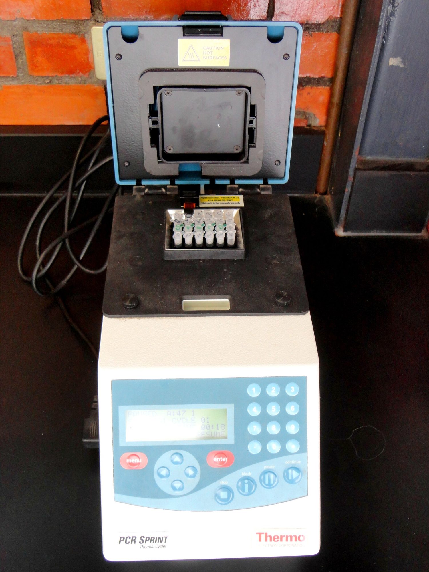 A benchtop thermal cycler with its lid open