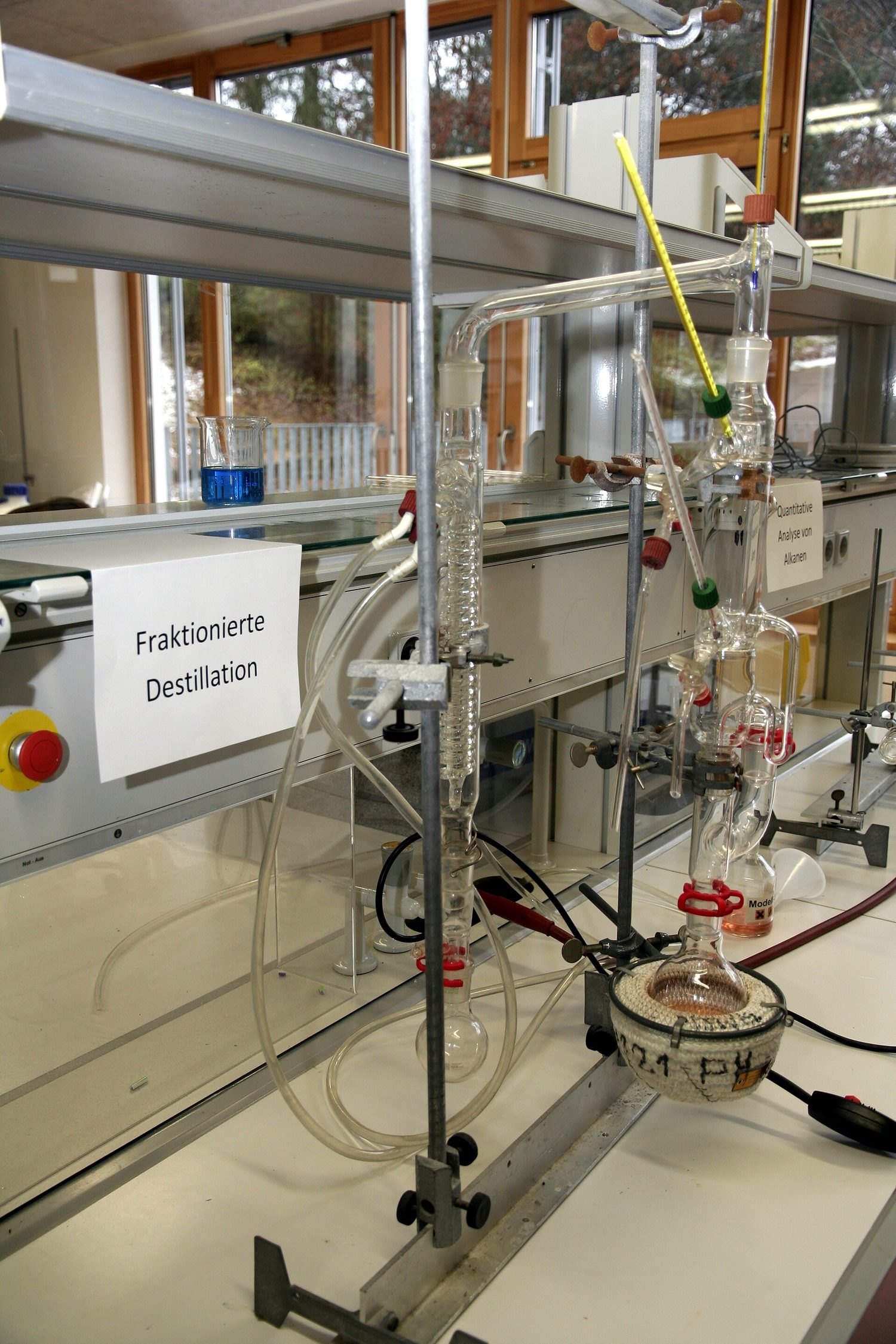 A laboratory fractional-distillation column with a thermometer and water condenser