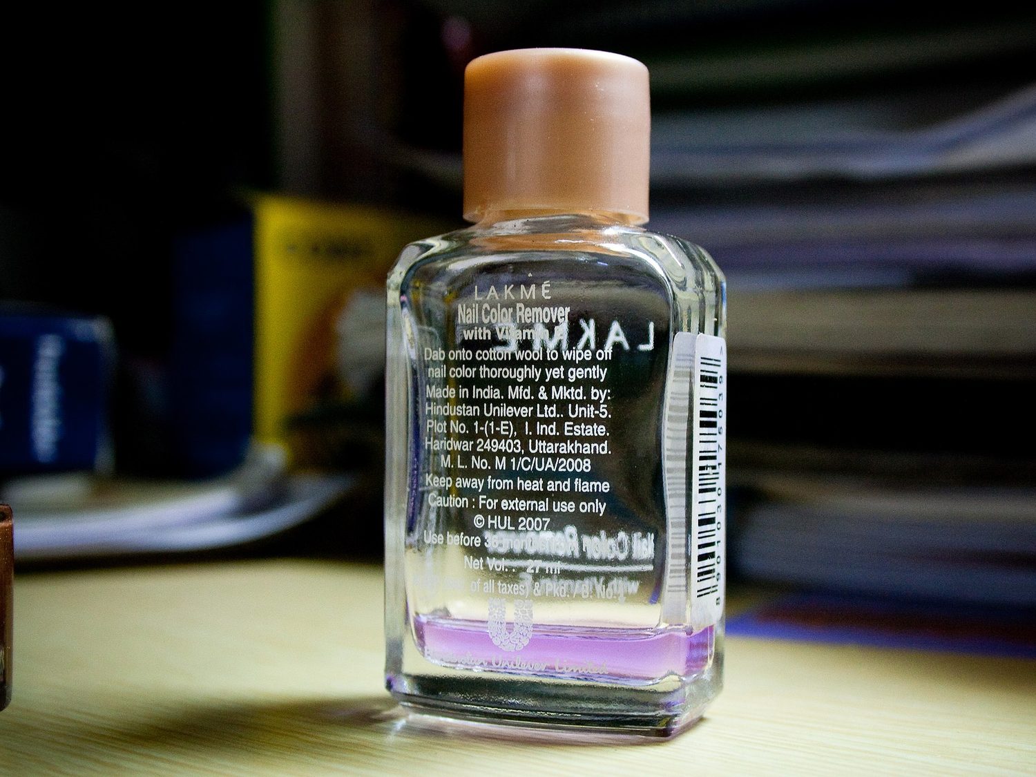 A bottle of nail-polish remover beside cotton pads