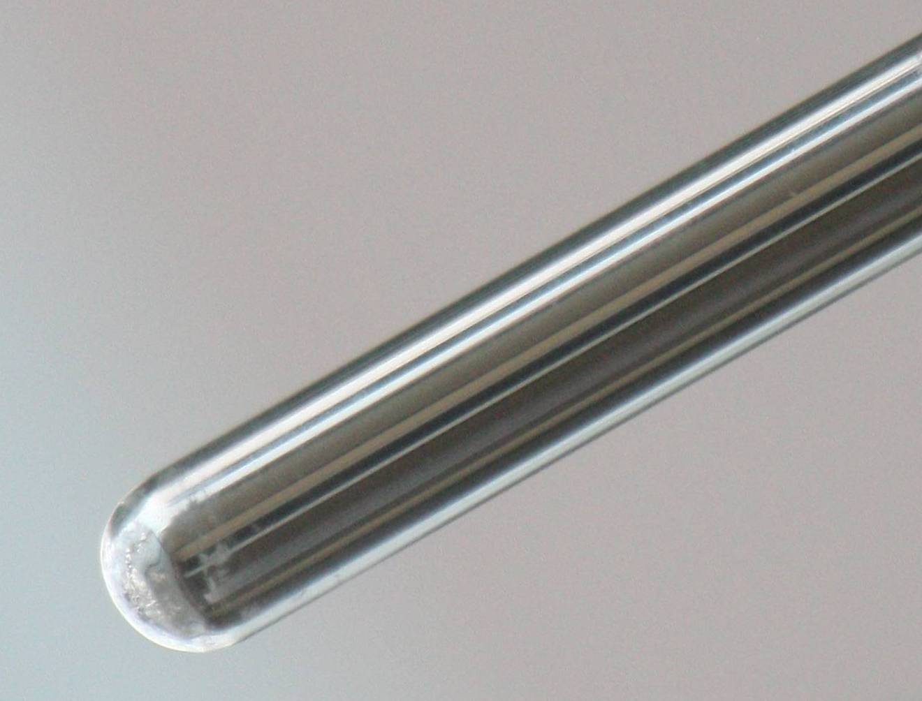 A test tube whose inner wall is coated with a bright, shiny silver layer, like a mirror