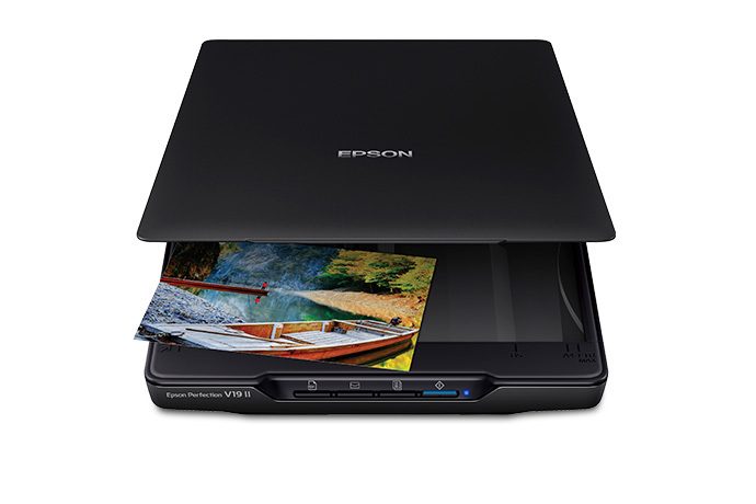 A flatbed scanner on a white background, with a photo coming out of the front after scanning