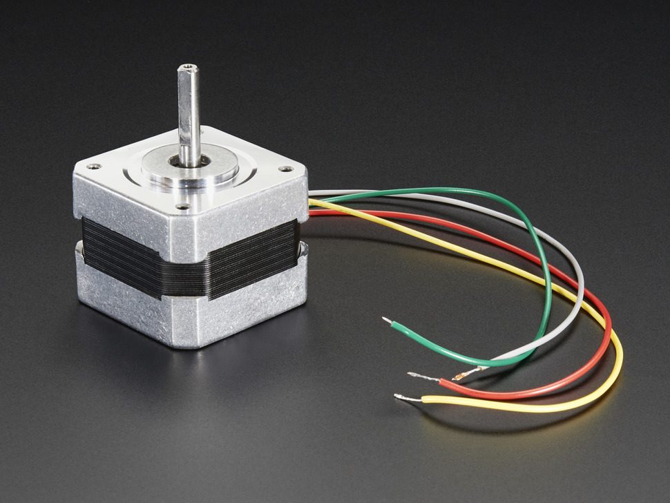 A small metal stepper motor with a central shaft and coloured wires, on a dark studio background
