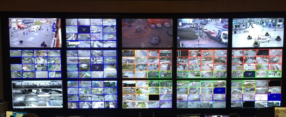 A wall of CCTV monitors in a control room