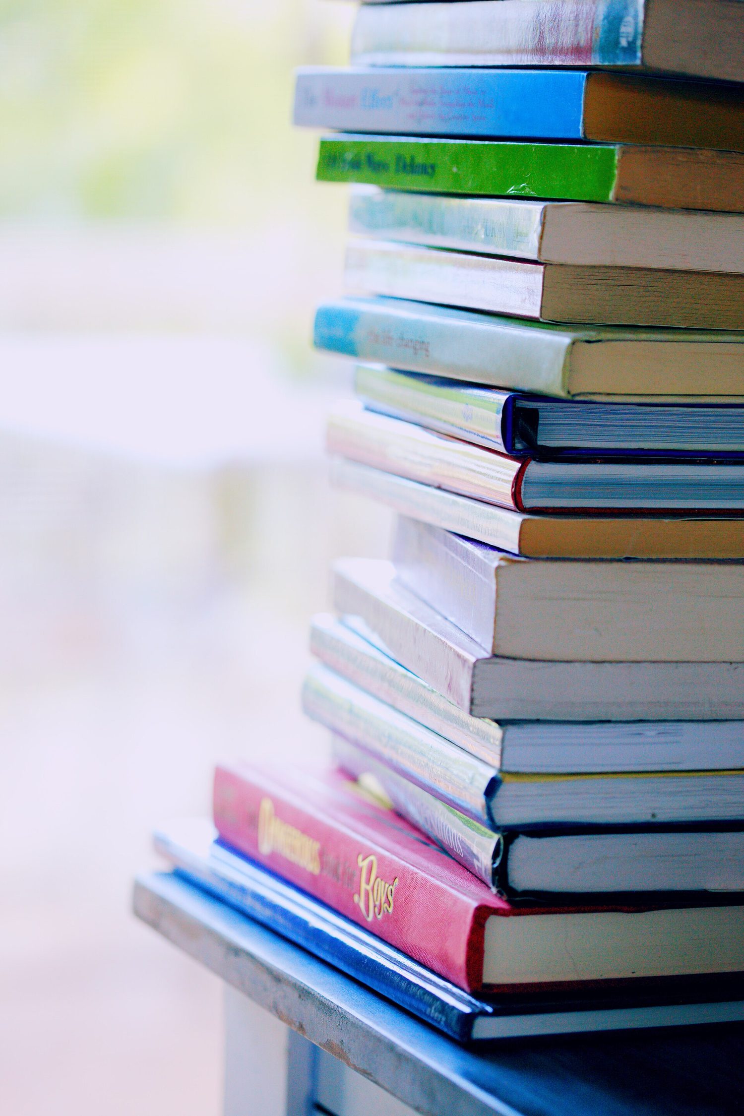 A tall pile of books stacked flat on top of one another