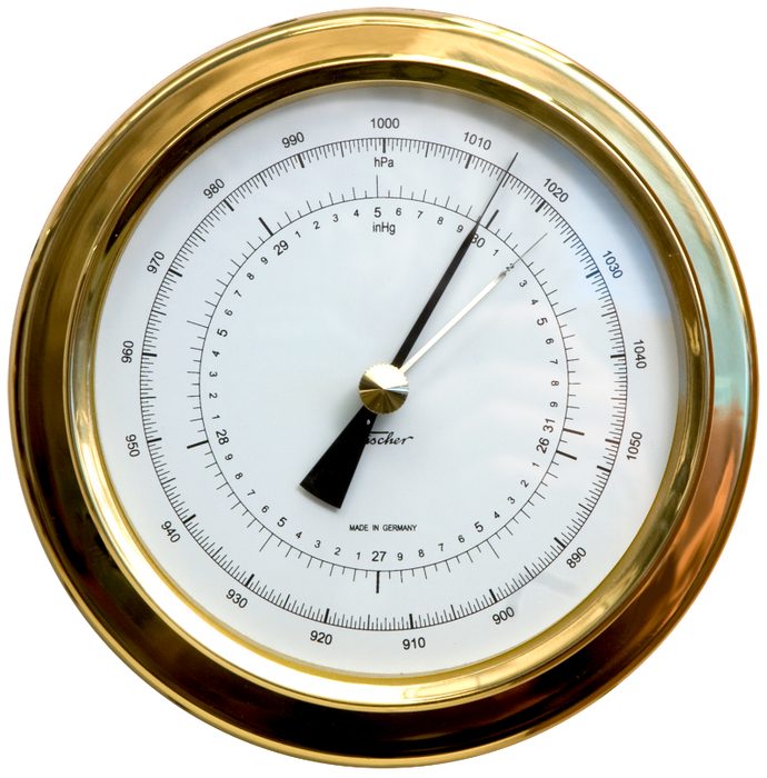 A precision aneroid barometer with a brass case and a white dial, its needle pointing to a scale marked in hectopascals (hPa) and inches of mercury (inHg)