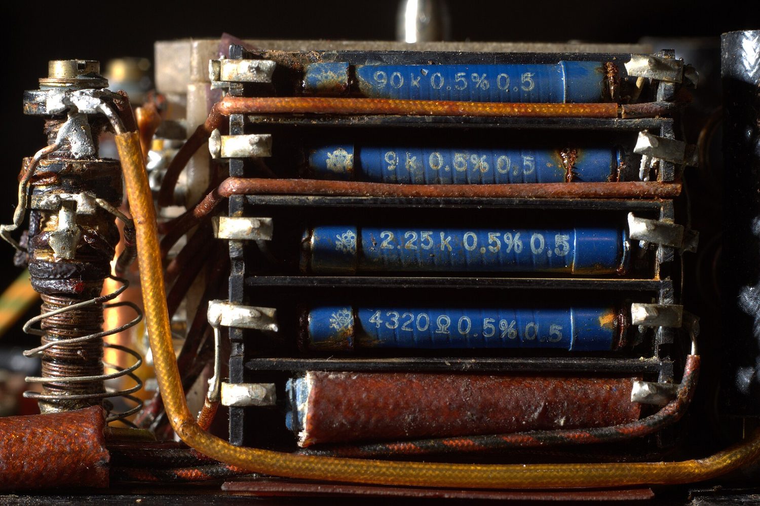 A digital multimeter with its probes across a bank of resistors