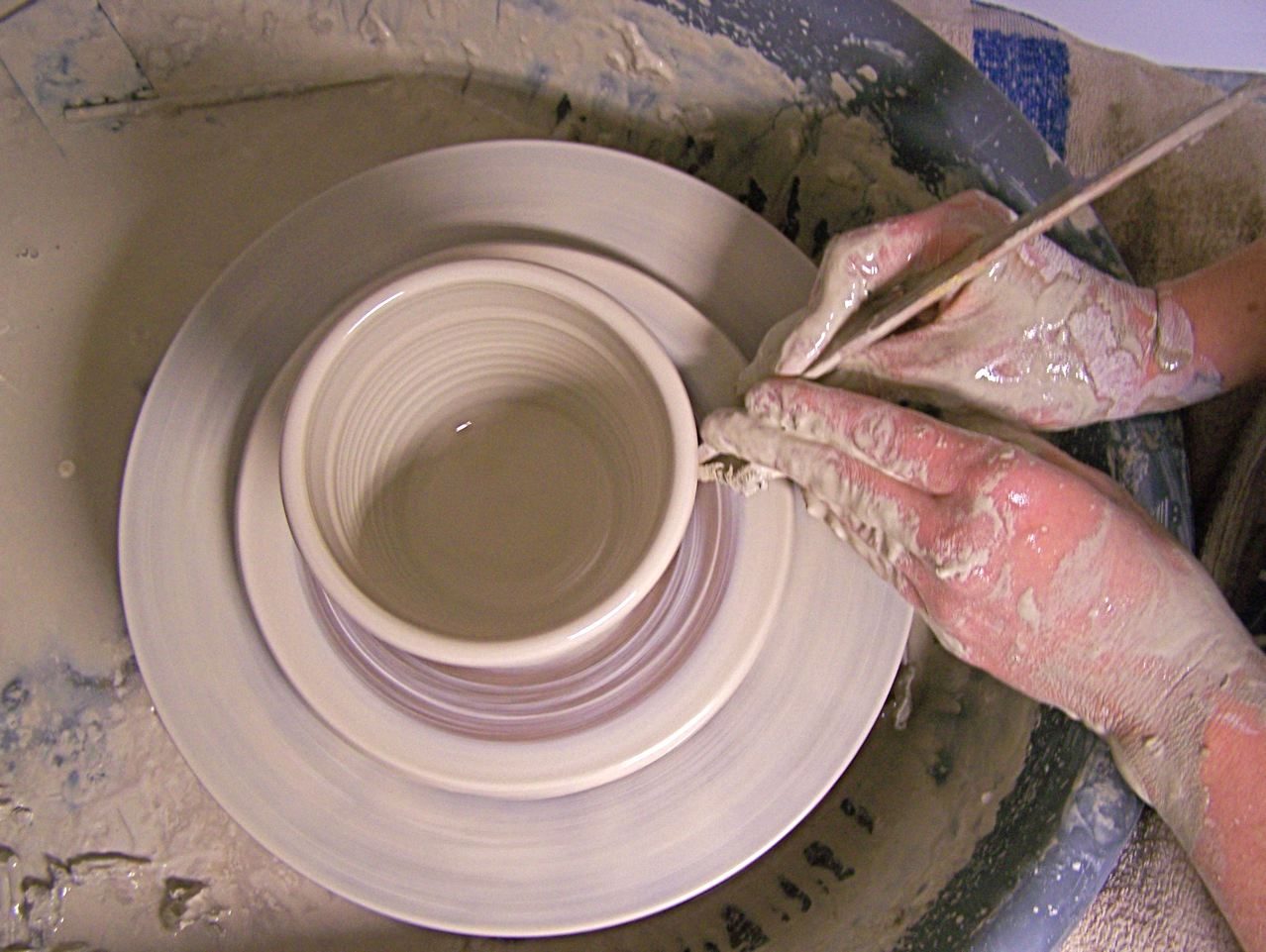 A potter shaping a vessel: solids of revolution are volumes formed by rotating a plane region