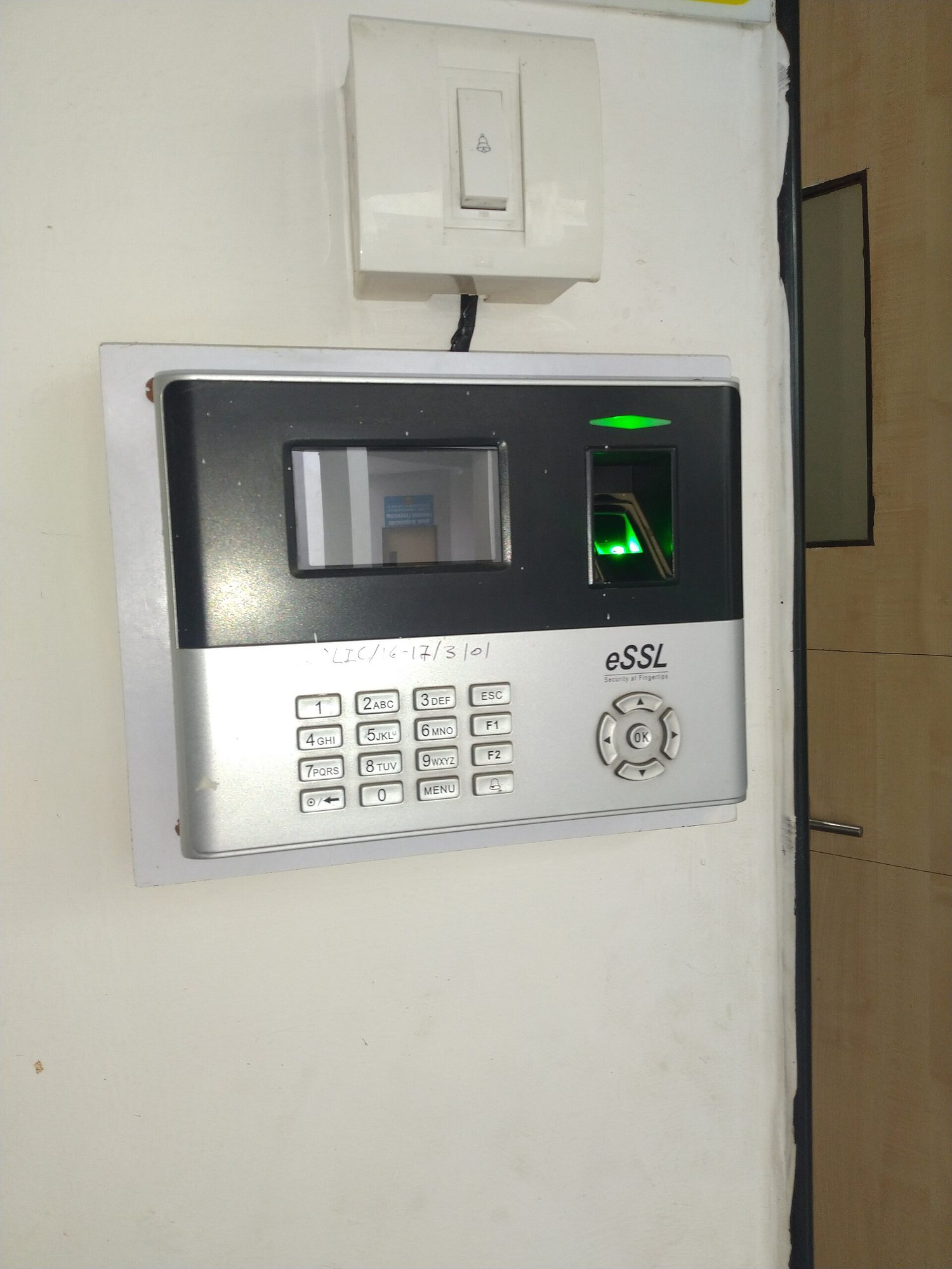 A person pressing a fingertip onto a small optical fingerprint scanner