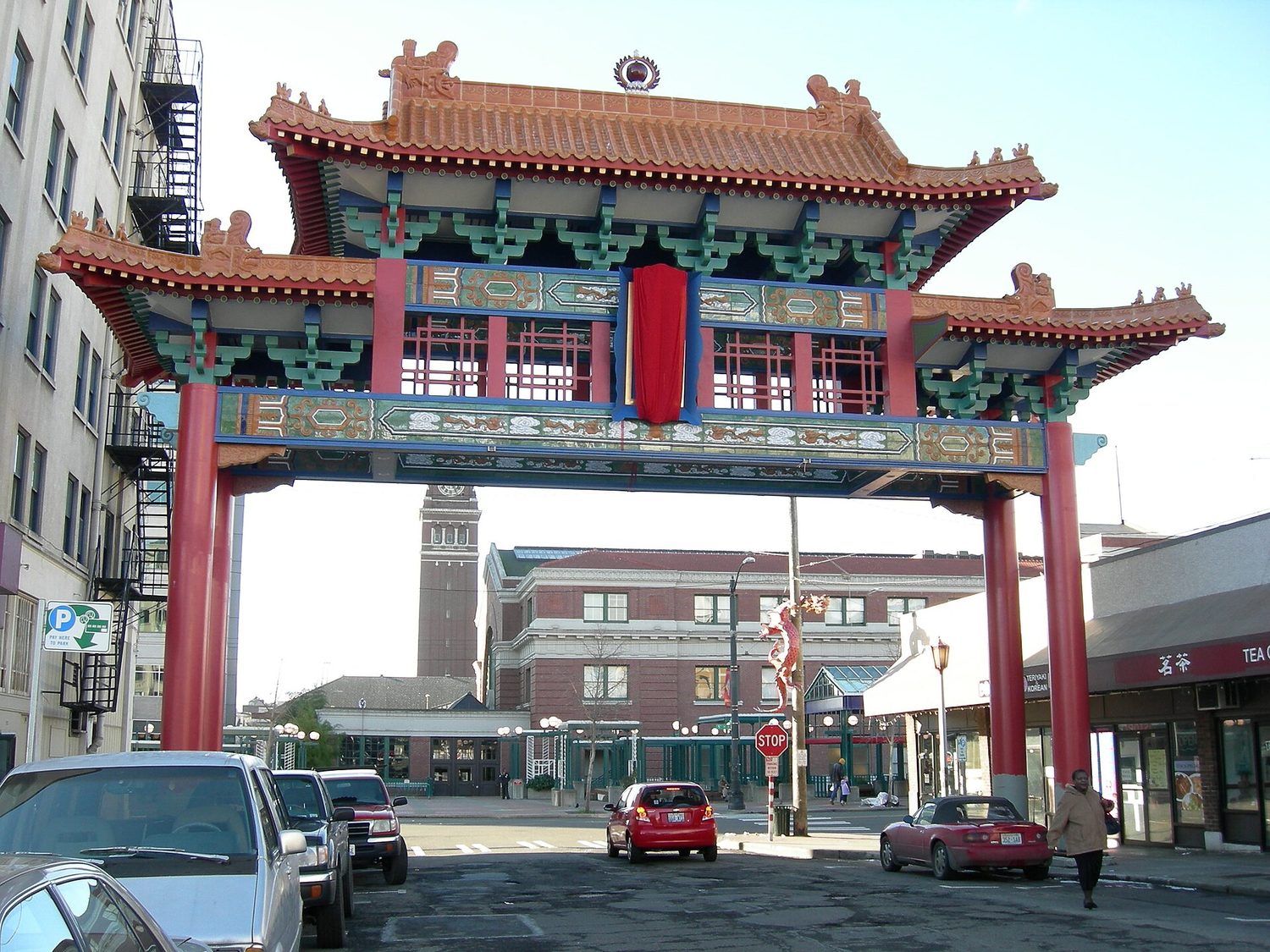 A large, ornate traditional Chinese archway with a green tiled roof spanning a street, marking the entrance to Seattle's Chinatown