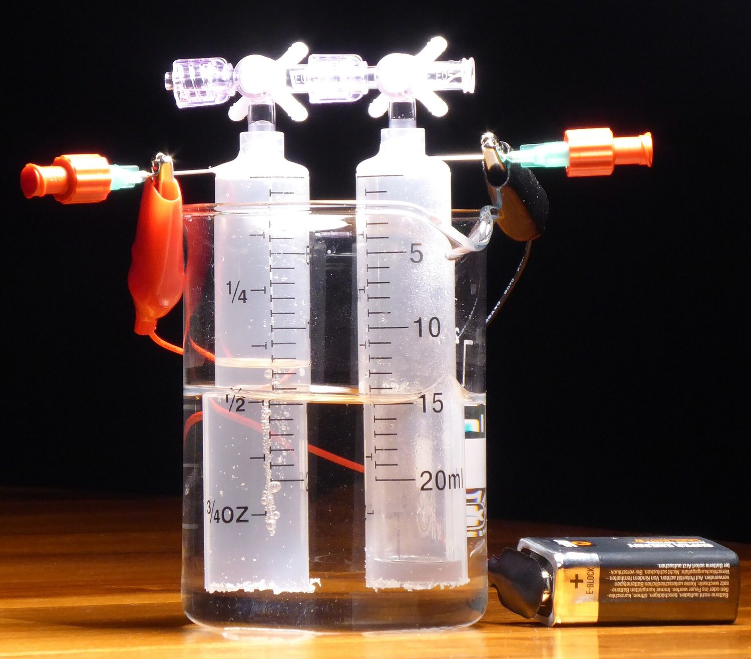 Electrolysis of water: gas bubbles off at each electrode and collects in the tubes above