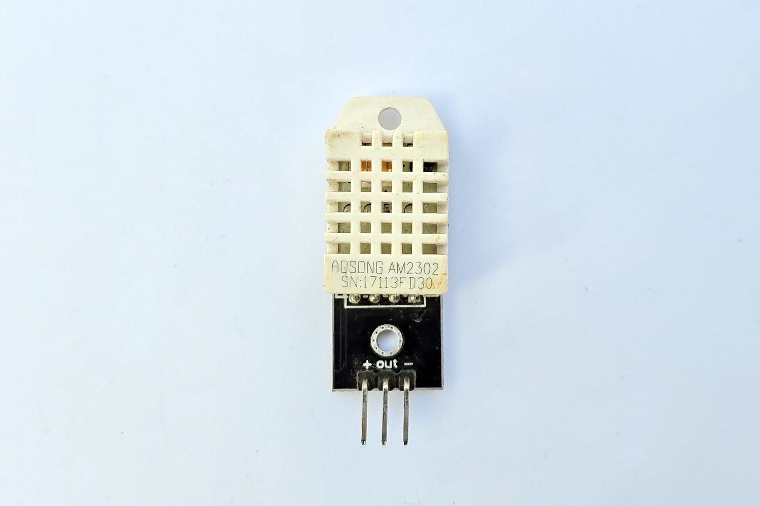 A small blue-and-black temperature sensor on a tiny circuit board with three pins