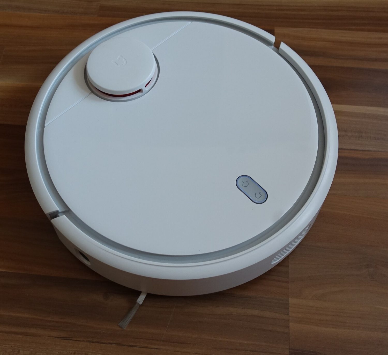 A round, flat grey robot vacuum cleaner seen from above, with S, M and L buttons on top