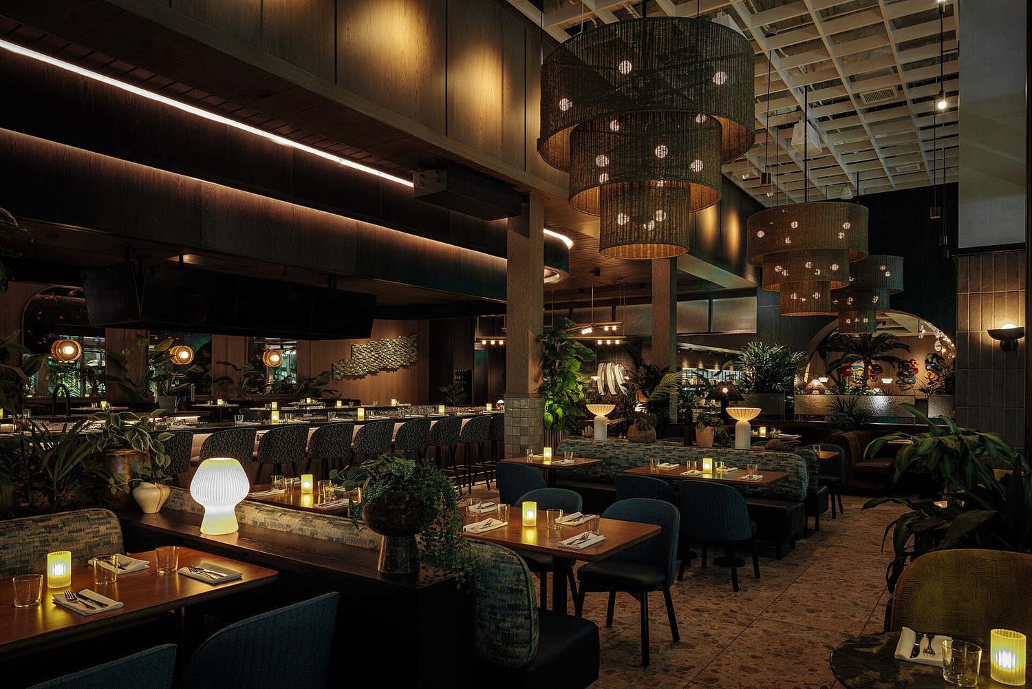 O interior de um restaurante inteligente: iluminação baixa, assentos em baú e mesas postas