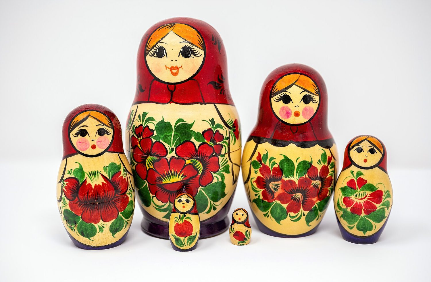 A row of six Russian nesting dolls of the same design, each a different size