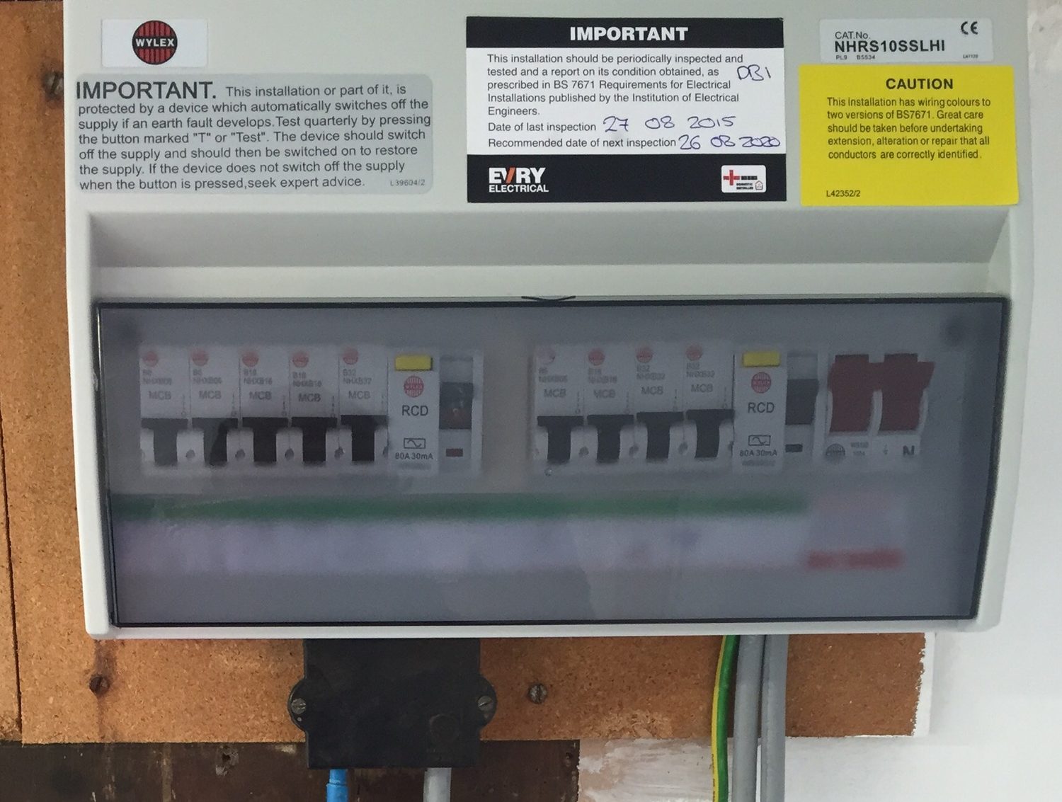 The inside of a home consumer unit showing a row of miniature circuit breakers and two RCD trip switches