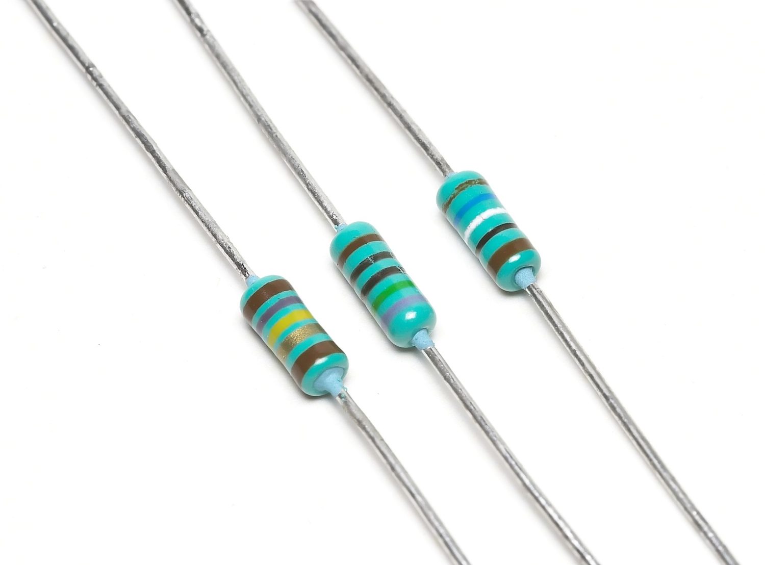 Rows of small resistors held in paper tape, each with coloured bands and two wire legs