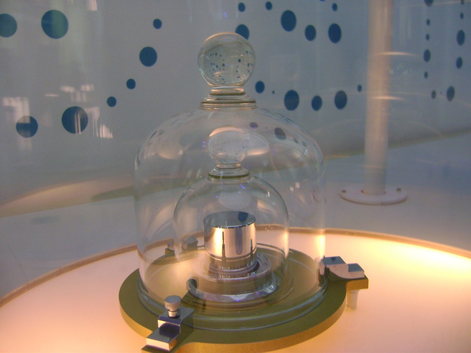 Una réplica del prototipo del kilogramo, un cilindro de metal guardado bajo frascos de vidrio